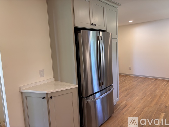 A kitchen with a stainless steel refrigerator and cabinets.