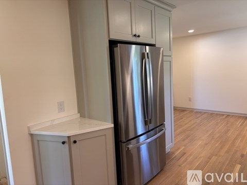 A kitchen with a stainless steel refrigerator and cabinets.