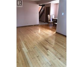 A room with wooden flooring and a chair.