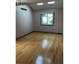 A room with wooden flooring and a window.