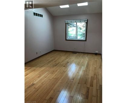 A room with wooden flooring and a window.