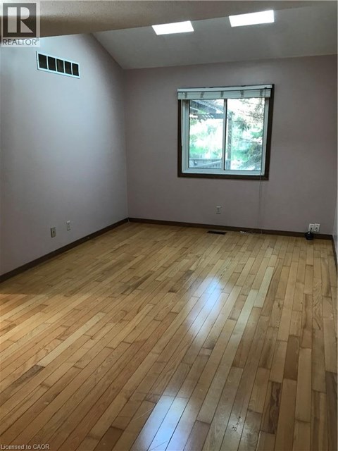 A room with wooden flooring and a window.