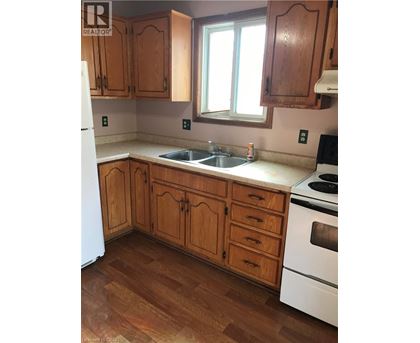 A kitchen with wooden cabinets and a white fridge.