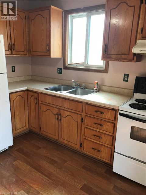 A kitchen with wooden cabinets and a white fridge.