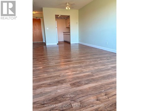 A room with wooden flooring and white walls.