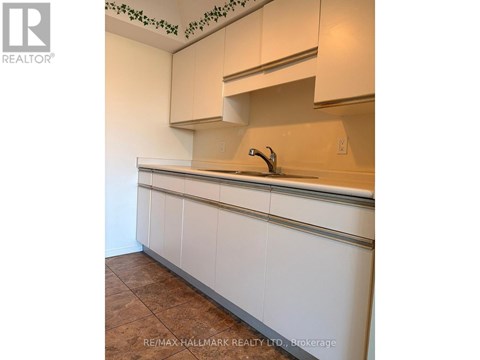 A kitchen with white cabinets and a brown floor.
