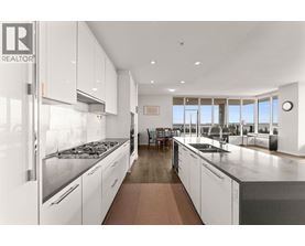 A modern kitchen with white cabinets and stainless steel appliances.