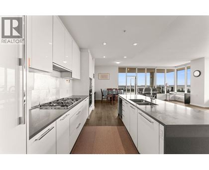 A modern kitchen with white cabinets and stainless steel appliances.