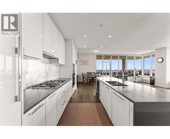 A modern kitchen with white cabinets and stainless steel appliances.