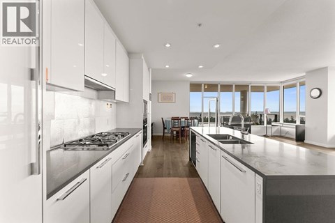 A modern kitchen with white cabinets and stainless steel appliances.