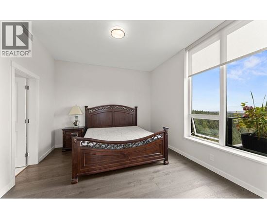 A bedroom with a large bed and a window overlooking the outdoors.