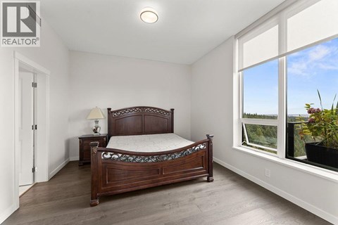 A bedroom with a large bed and a window overlooking the outdoors.
