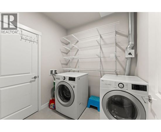 A laundry room with a washer and dryer and a white door.