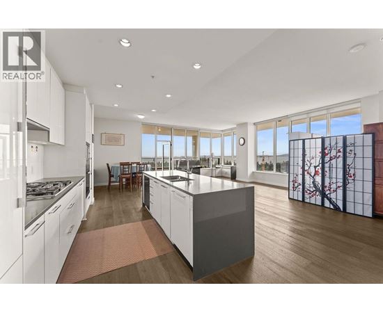 A modern kitchen with white cabinets and a large island.