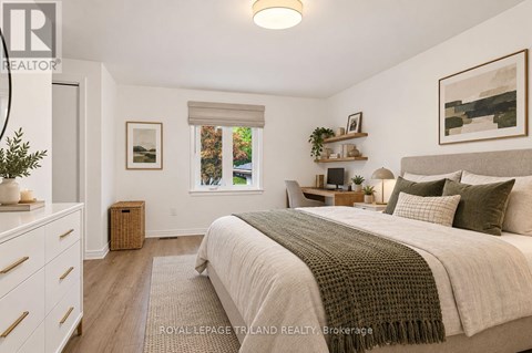 A bedroom with a large bed and a window with a view of trees.