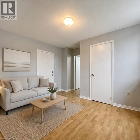A living room with a couch, coffee table, and two doors.