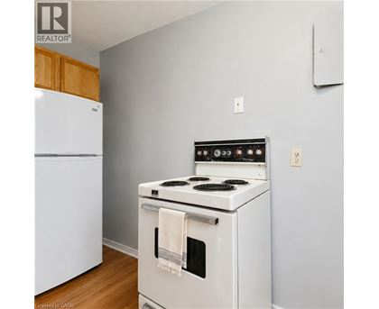 A white stove with a towel hanging on the oven door.