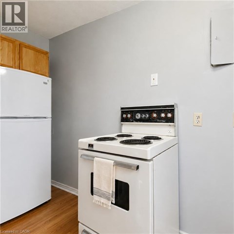 A white stove with a towel hanging on the oven door.
