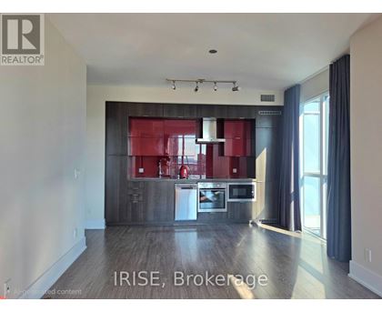 A modern kitchen with a red backsplash and stainless steel appliances.