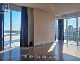 A spacious room with large windows overlooking a cityscape.