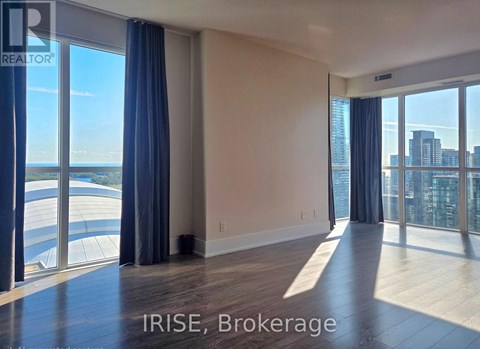 A spacious room with large windows overlooking a cityscape.
