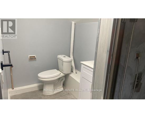 A white toilet in a bathroom with a white cabinet and a white towel rack.