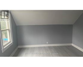 A room with a window and a grey wall.