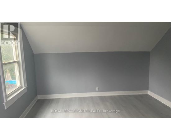 A room with a window and a grey wall.