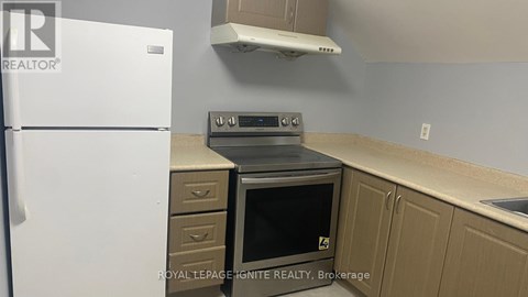 A kitchen with a white fridge, a stove and a microwave.