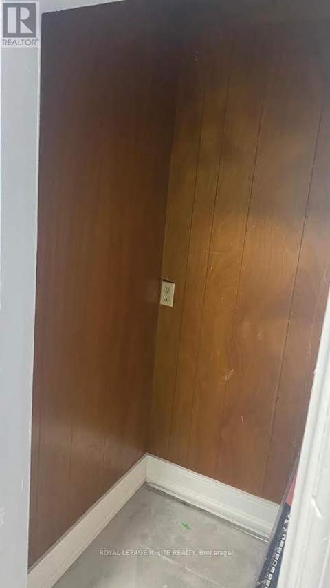 A room with a wooden wall and a white baseboard.