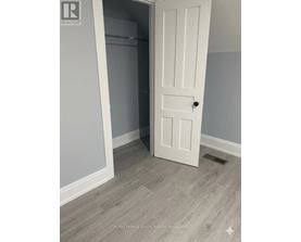 A white door is open to a room with a grey wall.