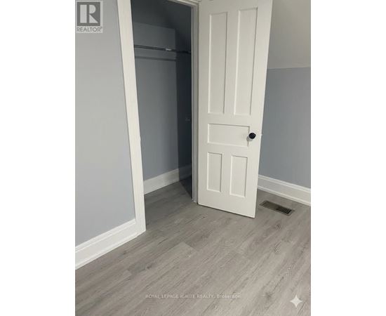 A white door is open to a room with a grey wall.