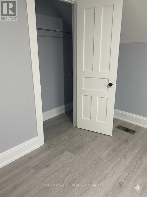 A white door is open to a room with a grey wall.