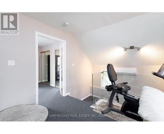 A room with a gym equipment and a bed.