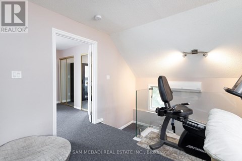 A room with a gym equipment and a bed.