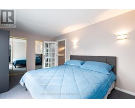 A bedroom with a bed covered in a blue comforter.