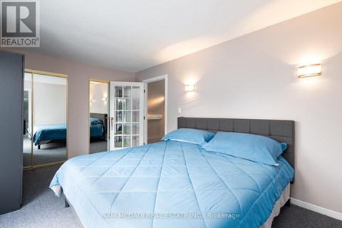 A bedroom with a bed covered in a blue comforter.