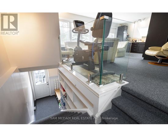 A living room with a glass table and a white couch.