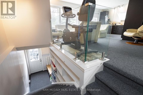 A living room with a glass table and a white couch.