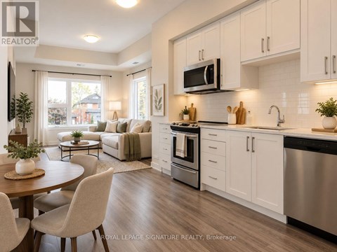 A hallway with a wooden floor leads to a kitchen.