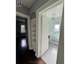 A hallway with a white door and a tiled floor.