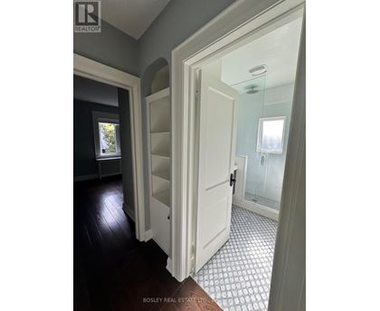 A hallway with a white door and a tiled floor.