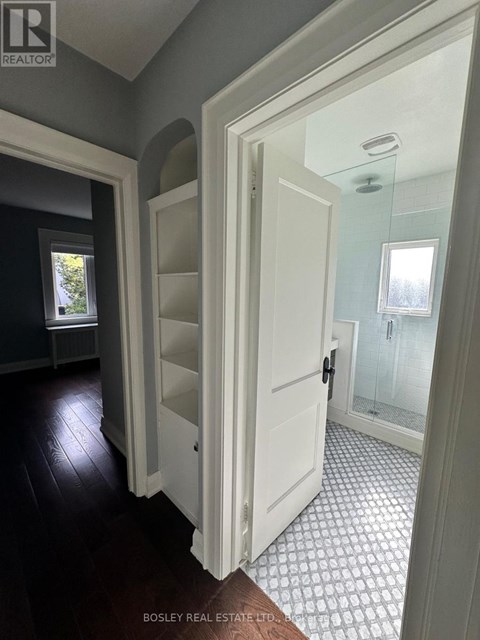 A hallway with a white door and a tiled floor.