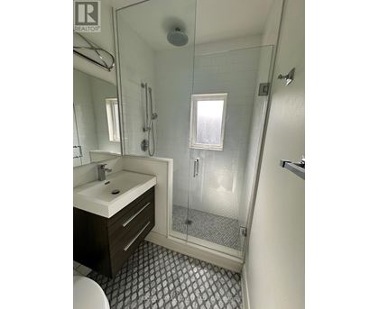 A bathroom with a sink, toilet, and shower.