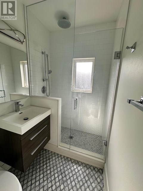A bathroom with a sink, toilet, and shower.