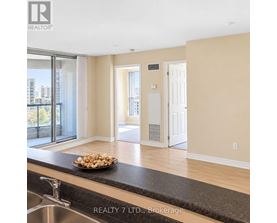 A bowl of popcorn sits on a countertop in a modern kitchen.