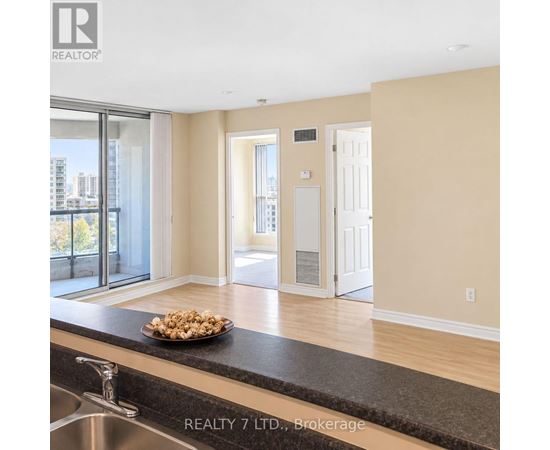 A bowl of popcorn sits on a countertop in a modern kitchen.