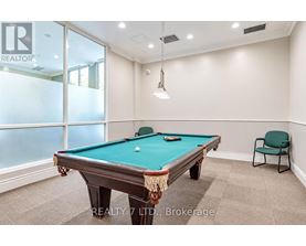 A pool table in a room with a chair and a window.