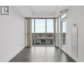 A spacious room with a view of the city through large windows.