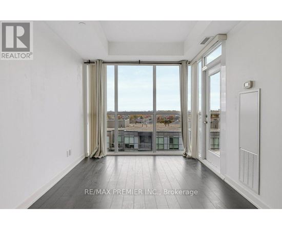 A spacious room with a view of the city through large windows.
